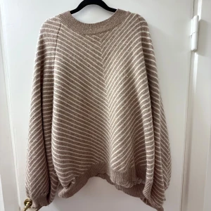 Beige och vit randig Kashmir tröja  - Mysig Kashmir tröja från Davida i beige med vita ränder. Tröjan har en loose passform, rund halsringning och långa ärmar. Såå snygg inför vinter och höst 