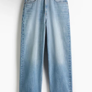 Ljusblå wide jeans med raka ben /baggy - Säljer ett par ljusblå jeans med bred passform och raka ben. Jeansen har klassiska fickor fram och bak, samt hög midja. Tillverkade i robust denim som ger en avslappnad och trendig look.