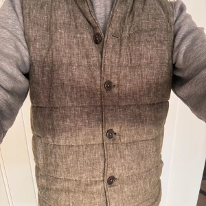  brun/grön väst från John Henric - Snygg väst från John Henric i storlek S, den är i en melerad brun nyans. Västen har knäppning med sex knappar framtill och en diskret bröstficka. Perfekt att slänga över en hoodie för en chill look. Inne fickan och ytterfickorna stängs med magneter, känns väldigt premium! Skick 10/10, använd 4-5 gg. Säljes pga för liten. 