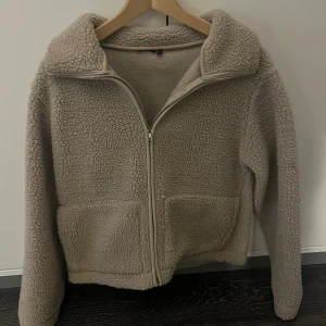 Beige teddyjacka med dragkedja  - Säljer min beiga teddyjacka från Lager 157 med krage och två stora fickor framtill. Jackan finns inte längre att köpa i butik i denna färg, därför är sista bilden en annan färg. Lappen i är dock bortklippt men inget som är märkvärdigt. Den är perfekt nu till hösten och säljer den då den inte kommer till användning för mig längre💕