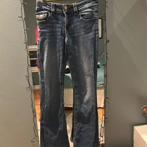 Blå bootcut low waist  jeans från Gina Tricot - Snygga blå jeans, bootcut och low waist från Gina Tricot i mellan blå färg. Är i storlek 170 passar S och XS