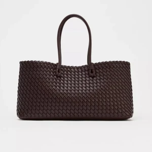 Brun flätad väska i skinn Zara - Snygg brun/vinröd väska med flätad design och två rejäla handtag. Väskan är tillverkad i skinn och har en rektangulär form som rymmer allt du behöver. Perfekt att bära över axeln eller i handen för en cool och stilren look.Aldrig använd🩷Perfekt nu för hösten