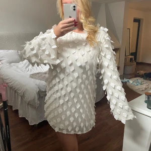 Vit klänning  - Vit klänning med fjädrar från Gina. Storlek 38. Använd en gång 