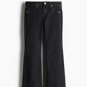 Svarta bootcut jeans - Snygga svarta jeans med bootcut-modell och klassisk femficksdesign. Jeansen har en mörk tvätt och raka ben som blir vidare nedtill. Perfekta för dig som gillar en tidlös och trendig look. Lågmidjade. Storlek 32.