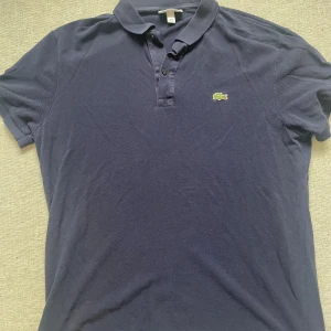 Lacoste piké - En mörkblå piké från märket Lacoste. Passar M. Pris kan diskuteras. Hör gärna av dig vid frågor eller fler bilder!