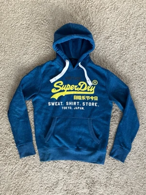 Superdry Hoodie - Blå Superdry Hoodie - Tröjan är i fantastiskt skick - Storlek: M - Pris: 349 - Först till Kvarn!