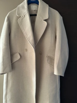 Beige ullkappa med knappar - Säljer min beiga kappa från H&M. Storlek xs, Passar mig som har M annars!!💕använd ca 4-5 gånger max därav som ny💕ordinariepris 699:-💕