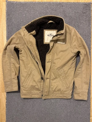 Pälsfodrad Hollister Fieldjacka - Säljer denna mycket snygga pälsfodrade Hollister fieldjacka! | Perfekt nu under vintern men även till våren! | Mycket bra skick! | Storlek M | Längd ≈ 70cm , Bredd armhåla - armhåla ≈ 53cm | Pris kan diskuteras!