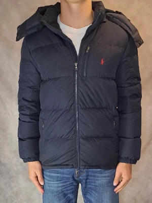 Marin blå vinter jacka från Ralph Lauren - Snygg marinblå vinter jacka  från Ralph Lauren i storlek Xl (18-20) som är som storleken Small i herr. Skick 8,5/10. Perfekt för kalla vinter dagar.