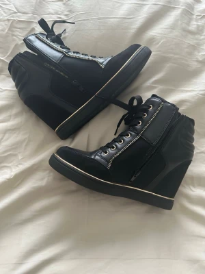 Isabel marant liknande skor - Snygga svarta high top sneakers med guldfärgade detaljer och dragkedjor på sidorna. Aldrig använda 💕💕