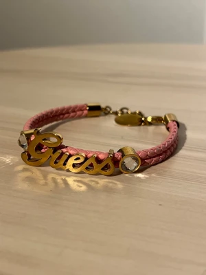 Guess armband i rosa och guld - Snyggt armband från Guess. Köpt i GUESS butik i Italien för några år sen. Justerbart spänne. 