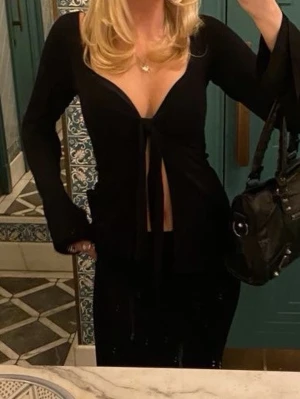 Svart urringad top  - Trendig svart omlottopp med knyt framtill och djup v-ringning.  Stolek m men passar mig i storlek xs🤍✨