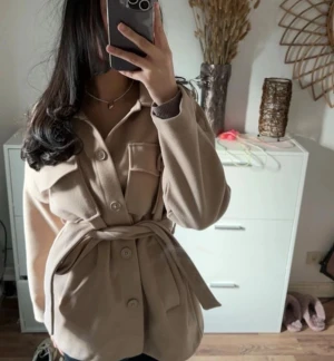 Gina tricot kappa  - Säljer en superfin kappa från Gina tricot i storleken S. Den är i jättebra skick och har bara använts ett fåtal gånger. Kappan är i beige färg som passar till det mesta!   Skicka gärna ett meddelande om du har frågor/ pris kan diskuteras!💓