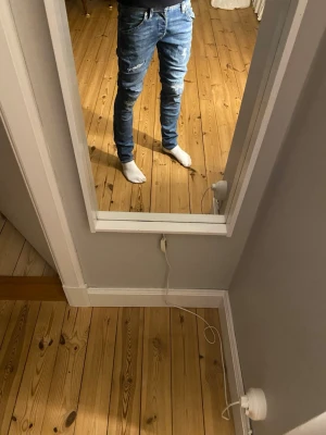 Slim Jack & Jones jeans med slitningar - Säljer ett par blå slim jeans med slitna detaljer på låren och knäna. Jeansen har klassisk femficksdesign. Perfekta för dig som gillar en modern och trendig look. Nypriset på dess är runt 650 och är hur bra skick som helst med inga defekter.