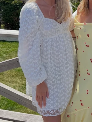 Vit blommig kortklänning - Söt vit kortklänning med blommigt spetsmönster. Perfekt för sommarens alla tillfällen till exempel student och midsommar 🤗 Från NAKD i storlek 38 och bara använd en gång 🥰
