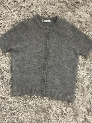 Stickad kofta från ZARA - Kortärmad grå stickad kofta från ZARA. Tröjan är använd ett par gånger.  