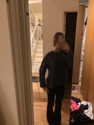 Mörkblå stickad tröja - En enkel och oversized mörkblå stickad tröja med rund halsringning och långa ärmar. Tröjan har en mjuk och lite luddig struktur som ger en avslappnad vibe. Perfekt att slänga på sig när det är kyligt ute.