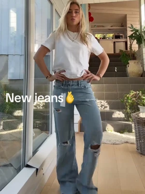 Ljusblåa wide ripped jeans - Säljer ett par ljusblåa jeans med bred passform och slitna detaljer på knäna. Har använt dom men är fortfarande i väldigt bra skick! Bilderna är inte mina men det är exakt dom jeansen💓