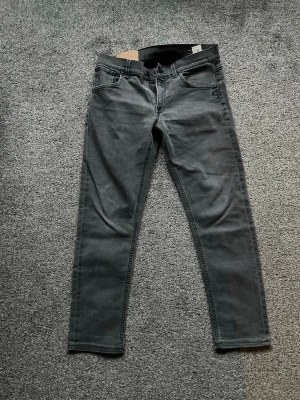 Grå Dondup jeans - 👖 Dondup jeans – storlek 30 Snygga Dondup jeans i svart tvätt med slim/avsmalnande passform. Stilrena fade-detaljer som ger en modern look. Original Dondup  Storlek 33 📦 Skick: Bra begagnat skick, se bilder.