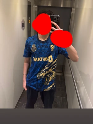 FC Porto blå draktröja - Snygg blå matchtröja från FC Porto med stort drakmotiv i gult och detaljer i guld. Tröjan har klubbmärke, sponsorlogga och korta ärmar. Perfekt för dig som älskar fotboll och vill sticka ut på planen. Den är i perfekt skick ba lite stickad, använd 1 gång