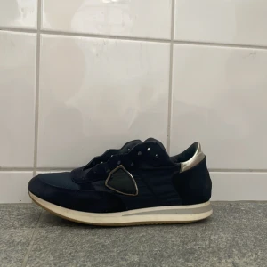 Philippe model trpx mörkblå - Man får också med ett par skosnören till dom.dom är 36 men passar mig med 38 Snygga mörkblå sneakers med en vit sula och silverdetaljer vid hälen. Skorna har snörning och en stilren design som passar perfekt för en casual look.