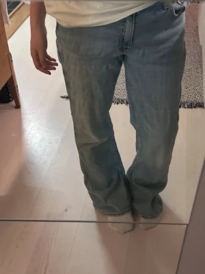 Ljusblå bootcut jeans - Säljer ett par ljusblå jeans från Gina Tricot, och klassisk femficksdesign. Jeansen är lågmidja och är tillverkade i mjukt denimtyg som ger en avslappnad cool vibe. Perfekta till sneakers. Passform för 158.