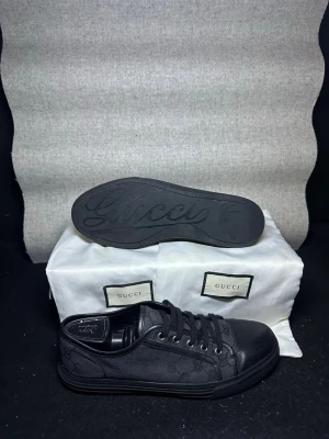 Gucci skor -  svarta sneakers från Gucci med klassiskt GG-monogram i textil och detaljer i skinn samt snygga detaljer under sulan. Lite slitage längst fram på skorna som syns på bilderna samt på sulan men ingen man märker av vid användning. Dustbags ingår. Tveka inte på att höra av dig om du undrar över något, pris kan diskuteras✅💯