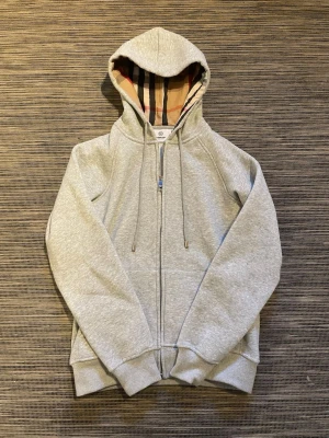 Grå Burberry hoodie - Säljer en grå Burberry Hoodie! Hoodien är helt oanvänd och har inga defekter osv! Hör av er vid intresse, snabb leverans!!