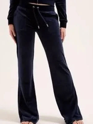 Mörkblåa mjukisbyxor med snörning - Snygga mörkblå mjukisbyxor i mjuk velour med breda ben och snörning i midjan. Byxorna har två fickor bak med knappdetaljer och en relaxed passform som ger en chill vibe. Perfekta för att maxa komforten och ändå se stilren ut.