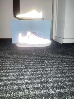  Philippe Model Tropez 2.1 Low Man reflex_gris - Snygga grå sneakers från Philippe Model med vita detaljer och vita skosnören. Skorna har en klassisk låg siluett och är tillverkade i mocka och textil. Perfekta för dig som vill ha en clean och stilren look. Dom är lite trasiga men de är värda 3000kr. Därför är det prisvärt. Priset kan sänkas. 