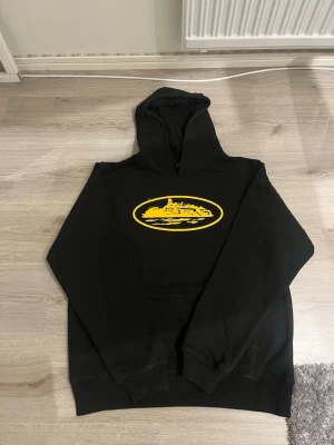 Corteiz Hoodie svart - Svart Corteiz hoodie med gul logga. Endast testad av mig fåtalgånger. Säljs på grund av att den är för stor så inget fel på den alls. Storlek L