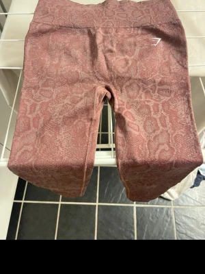 HELT NYA   leggings Gymshark - Snygga rosa leggings från Gymshark med leopardmönster och hög midja. Stretchigt material som sitter tight och bekvämt. Perfekta för dig som vill ha ett trendigt träningsplagg med coolt mönster och diskret logga på benet.