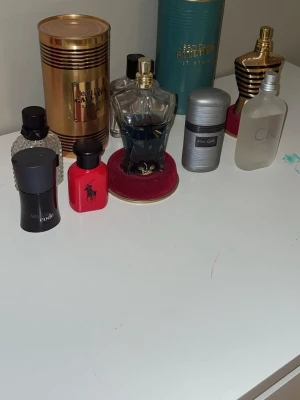 Mix av herrparfymer från kända märken - Samling med herrparfymer från Jean Paul Gaultier, Armani Code, Ralph Lauren Polo Red, Calvin Klein och Van Gils. Flaskorna har olika former och färger, bland annat svart, röd, blå och frostad glas. Perfekt för dig som gillar att variera doft.