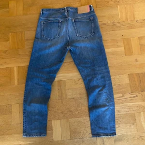 Acne jeans - Ett par ruggigt feta jeans ifrån acne studios med en vintage tvätt. Storlek 32/32. Skick 9/10 inga defekter.  Nypris ligger runt 3500, vårt pris 699. Skitfet tag på insidan. Har du några frågor kring bild med den på eller mått? Fråga på!