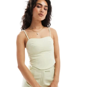 Pastellgrön korsett-topp med smala axelband - Oanvänd korsett-topp med smala justerbara axelband och nära passform. Dold blixtkedja på sidan. Fick två av misstag. Märket är Miss Selfridge, köpt på ASOS. Originalpris 429 kr.