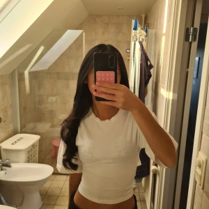 Vit tajt topp med knyt - Säljer en vit omlottopp från Lager 157 med knyt i ryggen och croppad passform. Toppen har rund hals, vida korta ärmar och är gjord i mjuk bomull. Perfekt för dig som gillar stilrena och trendiga plagg med lite extra detalj i ryggen.