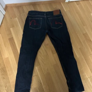 Evisu jeans mörkblå 31x34 - Mörkblå jeans från Evisu. Köpt på NK 2 år sen. säljer för de blivit för små.