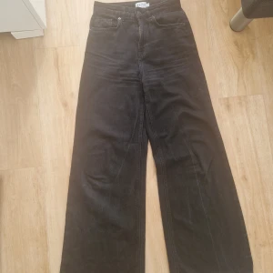 Svarta wide jeans från NA-KD - Säljer ett par svarta jeans från NA-KD med hög midja och breda ben. Klassisk femficksmodell med dragkedja och knapp framtill. Jeansen är tillverkade i bomull och har en stilren, enkel look som passar till det mesta.