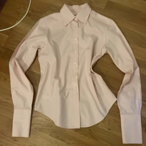 Ljusrosa Brooks Brothers skjorta  - - Brooks Brothers - Storlek 6/Xs - Mycket bra skick - 100 % bomull Brooks Brothers skjorta i storlek 6/Xs men tycker att den är stor nog att passa större men inte är säker. Passar till både formligt och vardagligt. Svara gärna på frågor om det behövs som bättre bilder