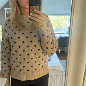 Beige stickad prickig tröja H&M - Beige stickad tröja från H&M med svarta prickar. Tröjan har använts max 10 gånger så den är i väldigt bra skick.