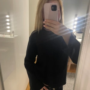 Svart stickad tröja - En svart stickad tröja med rund hals. Tröjan har en enkel och clean look, perfekt för dig som gillar basic men ändå vill ha något snyggt och bekvämt. Passformen är lite loose och den är lätt att styla till jeans eller kjol. Jätte snygg och perfekt till vintern