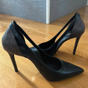 Klackskor  - Jag säljer dessa helt oanvända Michael Kors klackskor som är i storlek 39/40. Så fräscha och otroligt snygga! Klacken är 11 cm lång.