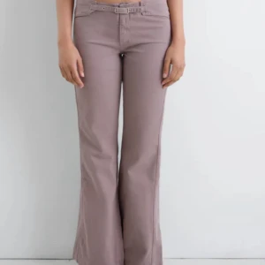 Gimaguas Nicole byxor - Nypris 129 euro. Storlek 38 men är små i storleken, passar S. Snygga beige bootcut byxor med tillhörande bälte och låg midja. Byxorna har raka ben som blir vidare nertill och är tillverkade i ett mjukt bomullsmaterial. Perfekta för en trendig och avslappnad look.