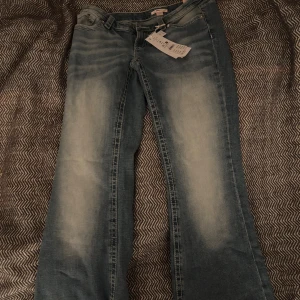 Ljusblå flare jeans M - Säljer ett par ljusblå hip hug flare jeans från FRD i storlek M. Jeansen har snyggt broderade bakfickor med mönster, låg midja och klassisk femficksdesign. Materialet är mjukt jeans och passformen är loose med bootcut-stil. Aldrig använt, bara testat. Någon i storlek 38-36 passar bra i dem. Är jätte bra skick ser helt oanvänd ut