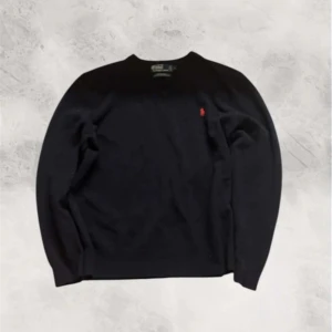 Stickad Ralph lauren - Svart stickad tröja från Polo Ralph Lauren i 100% lammull. Klassisk modell med rund hals och röd broderad logga på bröstet. Perfekt för lager-på-lager och passar till allt. Mjuk och varm känsla, ribbade muddar vid ärmslut och nederkant. Inga defekter fint skick, står L men passar som M, L. Kom privat för mer frågor!