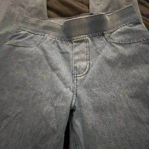 Blå jeans med resårmidja - Säljer ett par jus blåa jeans med resår i midjan och klassiska fickor både fram och bak. Jeansen utsvängda ben och är tillverkade i ett mjukt denimtyg som är skönt att bära. Perfekta för en avslappnad och stilren look.