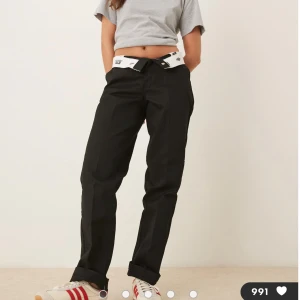 Svarta Dickies byxor straight fit - Svarta byxor från Dickies med klassisk rak passform och hög midja. Byxorna har diskret logga bak, hällor för bälte och är tillverkade i slitstark bomullsblandning. Aldrig använda lappar kvar