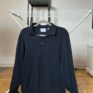 Marinblå pikétröja från Bläck - Marinblå pikétröja från Bläck med lång ärm.