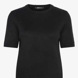 Svart stickad t-shirt från Gina Tricot - En svart stickad t-shirt från Gina Tricot med rund halsringning och korta ärmar. Enkel och stilren modell som är perfekt att matcha med jeans eller kjol. Mjuk och skön kvalitet som känns lyxig mot huden.