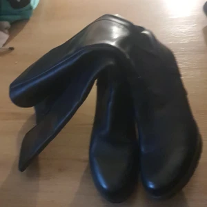 Svarta stövlar med klack och dragkedja - Säljer ett par svarta stövlar i skinnimitation med rund tå och låg klack. Stövlarna har dragkedja på sidan för enkel påtagning och en stilren look som passar till många outfits.